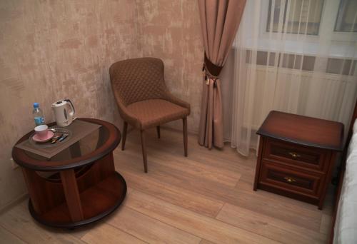 a room with a table and a chair and a table and stool at Centralnyi hotel in Poltava