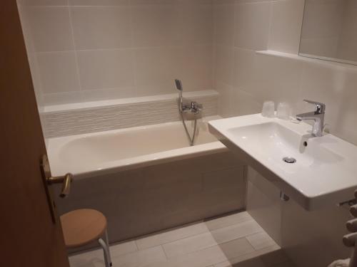 a bathroom with a sink and a bath tub at Hôtel-Restaurant A La Couronne in Kilstett