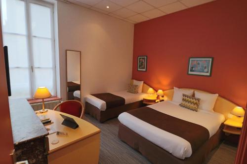 a hotel room with two beds and a desk at Logis-Hôtel des Oliviers in Thionville