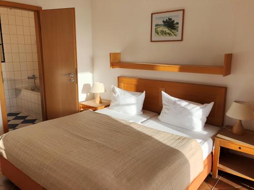 a bedroom with a large bed with white pillows at Hotel Enddorn Appartement in Grieben