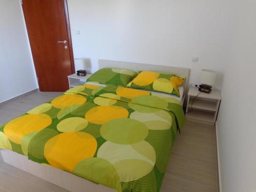 1 dormitorio con 1 cama con edredón verde y amarillo en Villa Palas Apartments, en Rogoznica