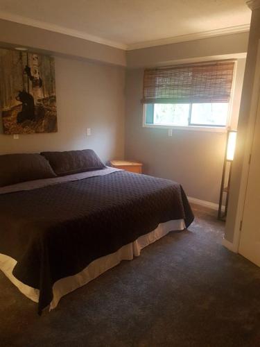 a bedroom with a large bed and a window at Riverbend Guest House in Chilliwack