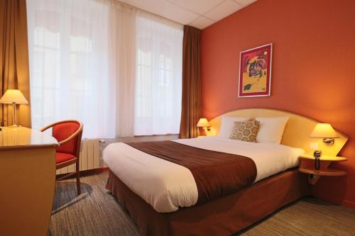 
a hotel room with a bed and a desk at Logis-Hôtel des Oliviers in Thionville
