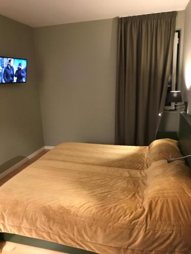 ein Bett in einem Schlafzimmer mit einem TV an der Wand in der Unterkunft Hotel Medieval® de Penedono in Penedono