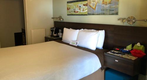 a hotel room with a large bed with white pillows at Bayfront Inn in Morro Bay