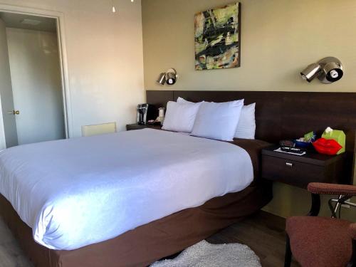 a hotel room with a large bed and a desk at Bayfront Inn in Morro Bay