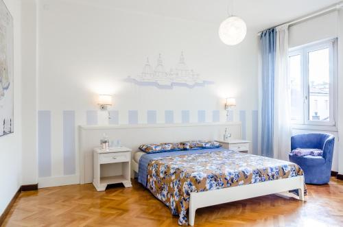 ein Schlafzimmer mit einem Bett und einem blauen Stuhl in der Unterkunft Appartamento Alloro in Treviso