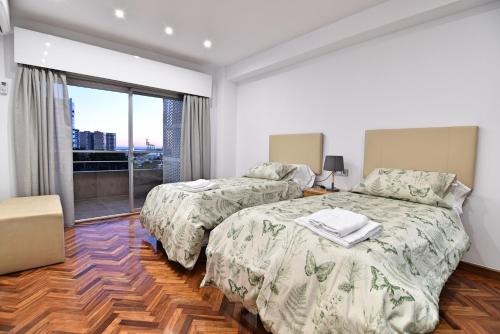 sypialnia z 2 łóżkami i dużym oknem w obiekcie Apartamento Luxury Reding w Maladze