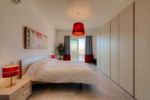 a bedroom with a bed and a red lamp at Seafront Apartment Sliema in Sliema