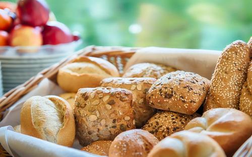 a basket filled with bread and buns on a table at Hotel Carolinenhof in Berlin