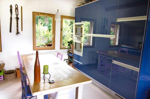 een keuken met een tafel en een blauwe muur bij Le Mont Fleuri Saint Gervais Les Bains in Saint-Gervais-les-Bains