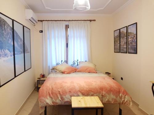 um quarto com uma cama com almofadas cor-de-rosa e uma janela em Hidden Gem Tirana em Tirana