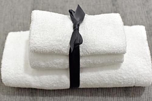 una pila di asciugamani bianchi con un fiocco nero di Gemini Suite a Salerno