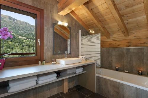 a bathroom with a sink and a tub and a window at Chalet Zebra in Méribel
