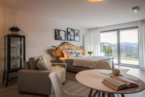 a bedroom with a bed and a table and chairs at ApartWisła in Wisła