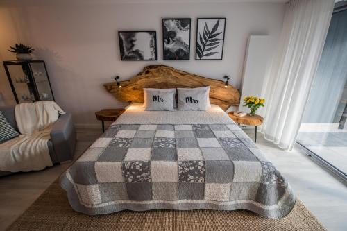a bedroom with a large bed with a checkered blanket at ApartWisła in Wisła