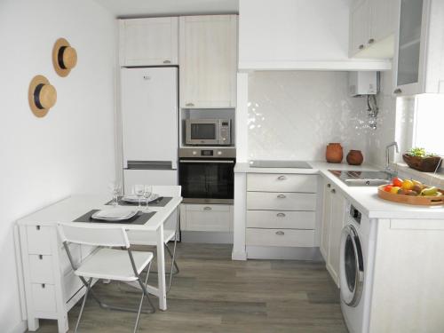 a white kitchen with a sink and a stove top oven at Serra da Pescaria House - Nazaré in Nazaré