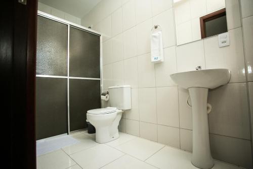 a bathroom with a toilet and a sink and a shower at Hotel Folley in Toledo