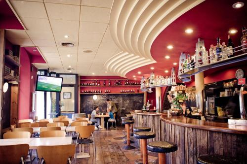ein Restaurant mit einer Bar mit Stühlen und einem TV in der Unterkunft Fonda Ca La Paula in Castellfollit de la Roca
