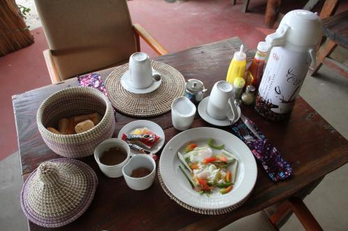a wooden table with plates of food on it at Nemasu Eco-lodge in Gunjur