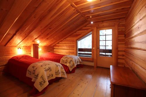 een slaapkamer met 2 bedden in een blokhut bij Villa Levinkajo in Sirkka