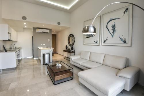 Menesse 32 - Penthouse Con Alberca Privada Vista Al Mar By Hola في بلايا ديل كارمن: غرفة معيشة مع أريكة وطاولة