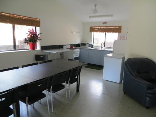 a kitchen with a table and chairs and a refrigerator at Fraser Forever Orchid Beach Fraser Island in K'gari Island (Fraser Island)