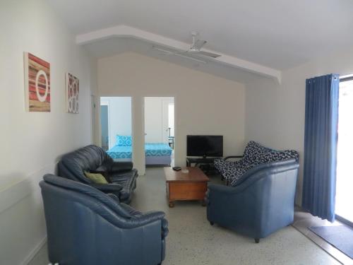 a living room with two chairs and a television at Fraser Forever Orchid Beach Fraser Island in K'gari Island (Fraser Island)
