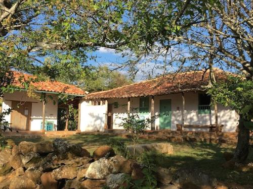 a house with a stone fence in front of it at Finca San Pedro in Barichara