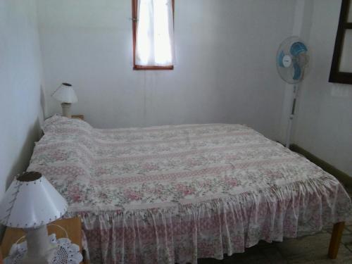 a bedroom with a bed and a window and a lamp at Complejo Leon in Villa Rumipal