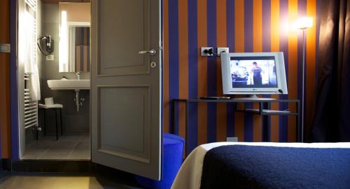 a room with a bed and a television on a table at Hotel Clocchiatti Next in Udine