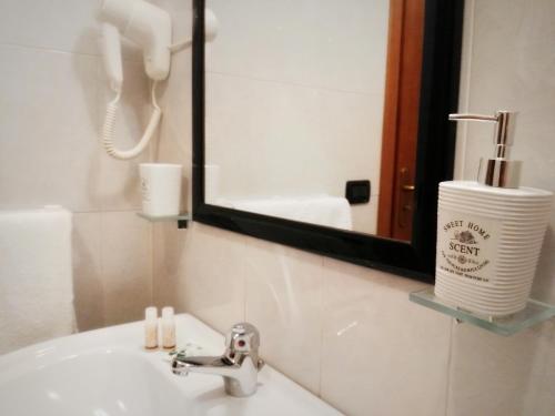 baño con lavabo con espejo y cepillo de dientes en B&B Main Street, en Reggio Calabria