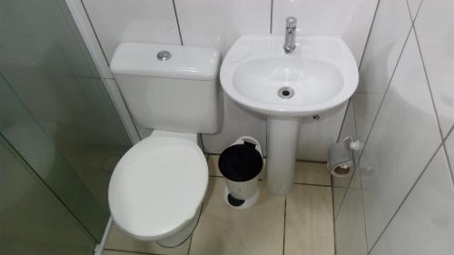 a bathroom with a white toilet and a sink at Hotel Carpe Diem in Sao Paulo