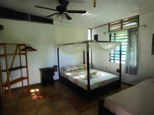 1 dormitorio con 1 cama y ventilador de techo en Cabinas del Mar, en Sámara