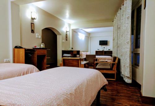 a hotel room with two beds and a living room at Yuru Retreat Delo in Kalimpong