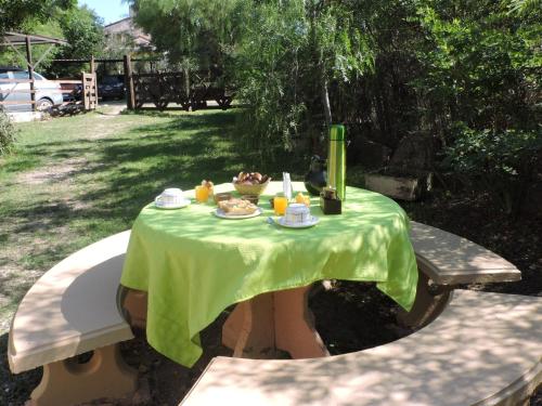 Cabañas La Comarca في ميرلو: طاولة عليها قماش الطاولة الخضراء مع الطعام