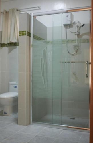 a glass shower in a bathroom with a toilet at La Natura Resort in Coron
