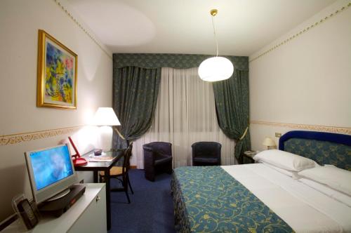 Habitación de hotel con cama y TV en Hotel Tosco Romagnolo, en Bagno di Romagna