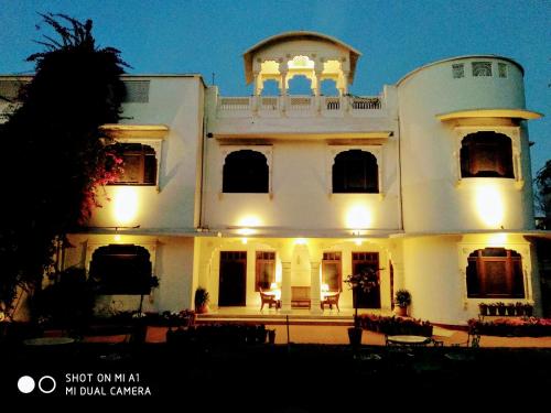 a large white house with a porch at night at Hotel Meghniwas in Jaipur