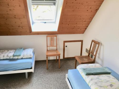 1 dormitorio con 2 camas, ventana y 2 sillas en Sitter-Panorama, en Bischofszell