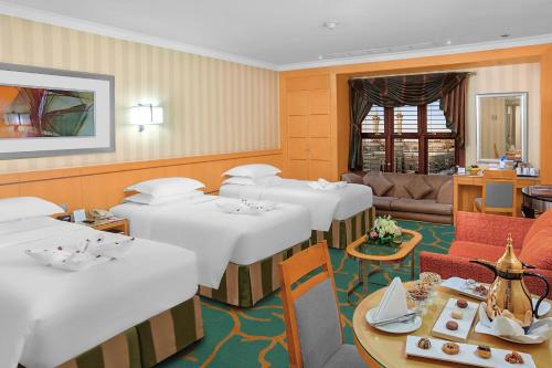 a dining room with white tables and a couch at Makkah Towers in Makkah