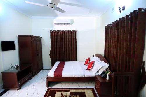a small bedroom with a bed and a tv at Novem Inn- Sylhet in Sylhet