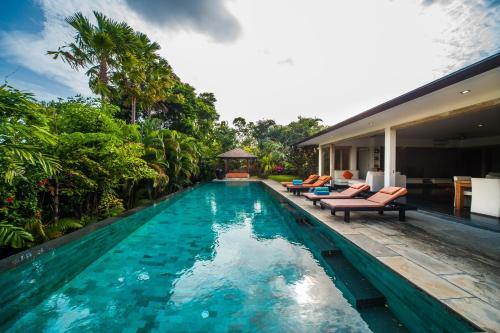 a swimming pool in the middle of a house at Amertha Villa Dreamland in Uluwatu