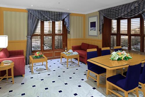 a living room with red and blue furniture and windows at Makkah Towers in Makkah