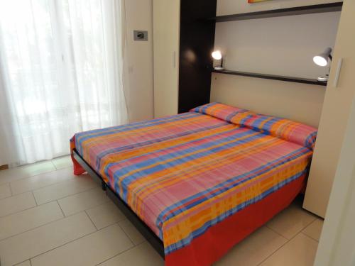 ビビオーネにあるIsolabella - Appartamentiのベッドルーム1室(ストライプ掛け布団付きのベッド1台付)