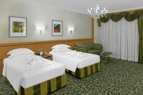 a hotel room with two beds and a chandelier at Makkah Towers in Makkah