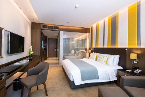 a hotel room with a large bed and a television at Lancaster Bangkok - SHA Extra Plus in Bangkok