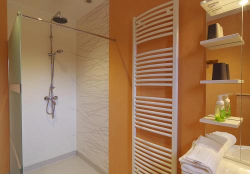 ein Bad mit einer Dusche und einer Glasduschkabine in der Unterkunft Auberge les Volpilières in Ruynes-en-Margeride