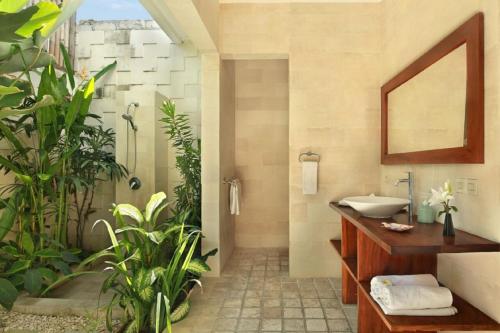 a bathroom with a sink and a shower with plants at Villa Blue in Seminyak