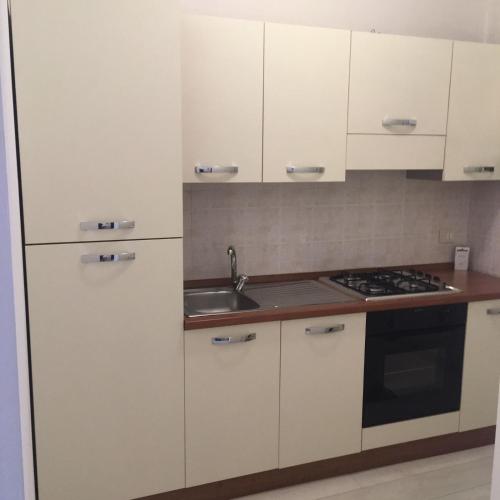 una cocina con armarios blancos y fregadero en Parea House 2 en Milán